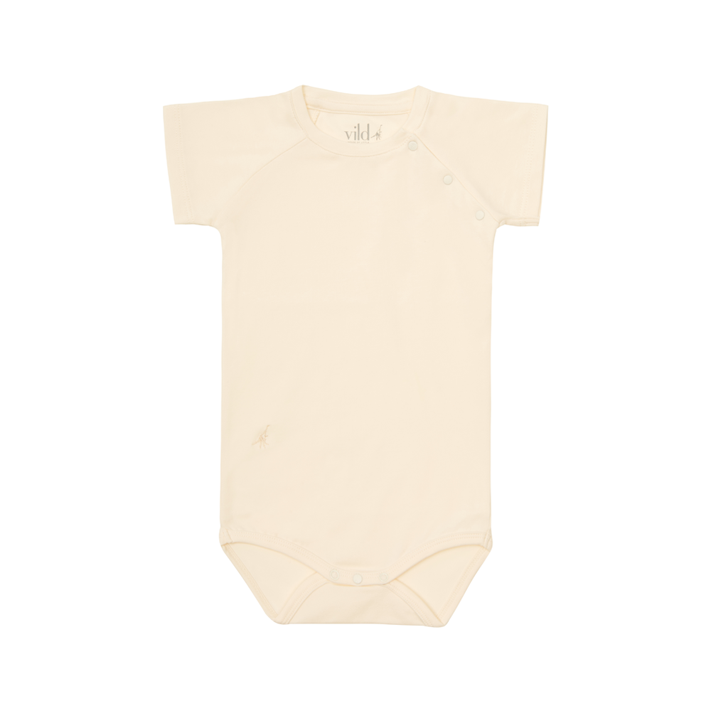 Organic cotton bodysuit. Brand: Vild  Colour: Ecru Details: Short sleeves, Slightly longer, slim body shape with straight style leg holes, Top neckline snappers, Eco-conscious, Soft, Perfect weight for warmer weather Composition: 95% Organic Cotton, 5% Elastane Made in: Portugal